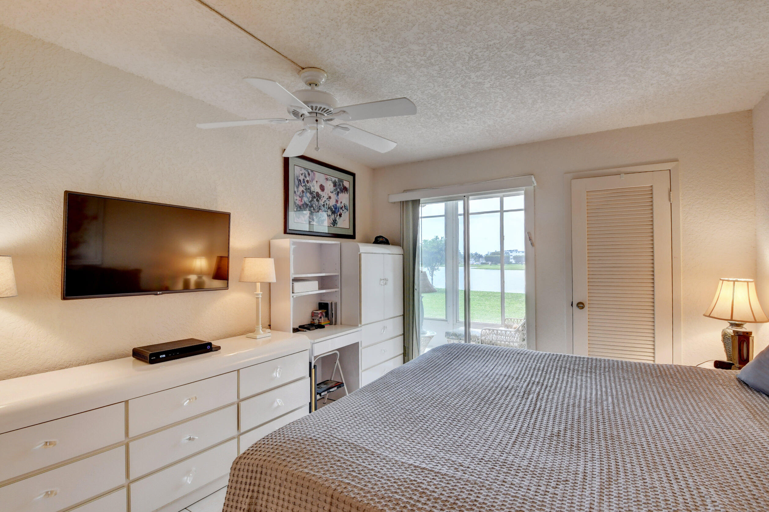 1045 Wolverton C, Unit 1045 Boca Raton, FL 33434 - Photo 20 of 67 a bedroom with a bed and a flat screen tv