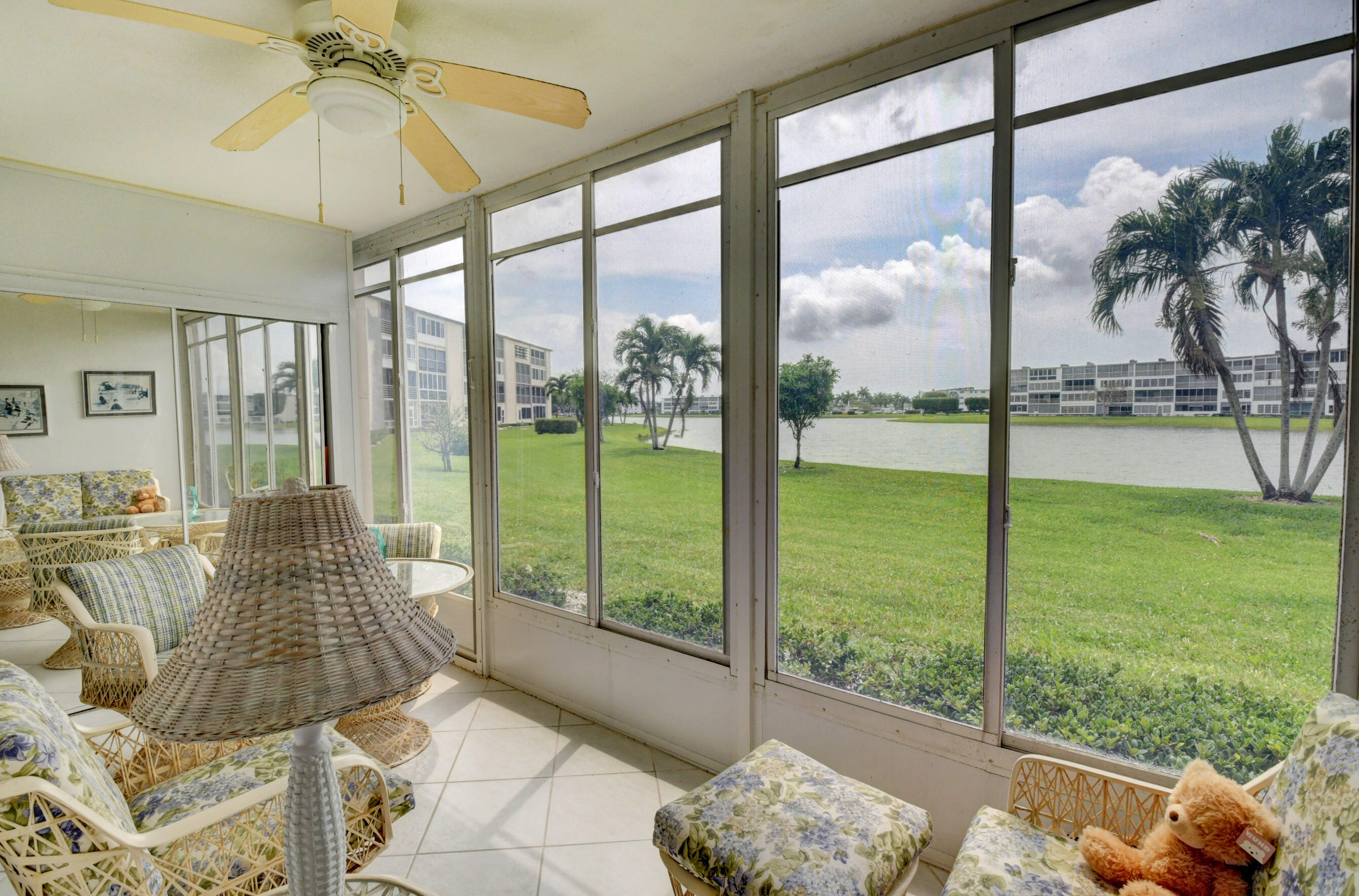 1045 Wolverton C, Unit 1045 Boca Raton, FL 33434 - Photo 30 of 67 a living room with couch and a floor to ceiling window