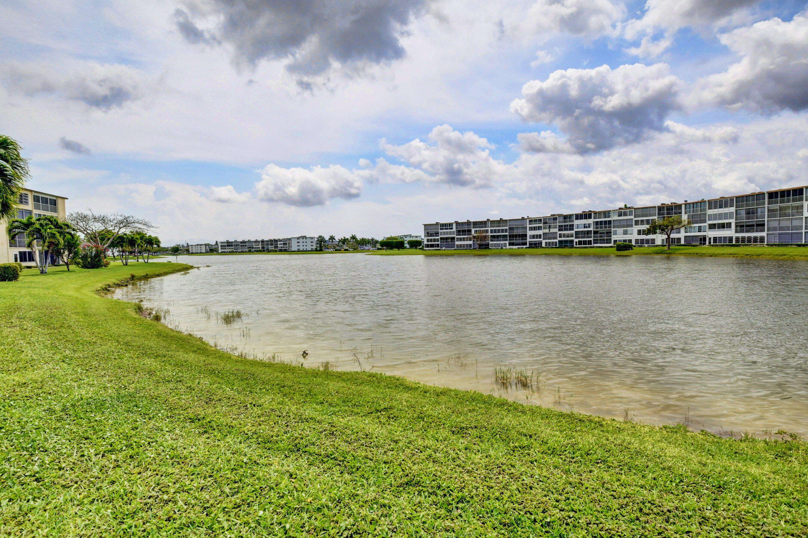 1045 Wolverton C, Unit 1045 Boca Raton, FL 33434 - Photo 32 of 67 a view of a lake with houses in the back
