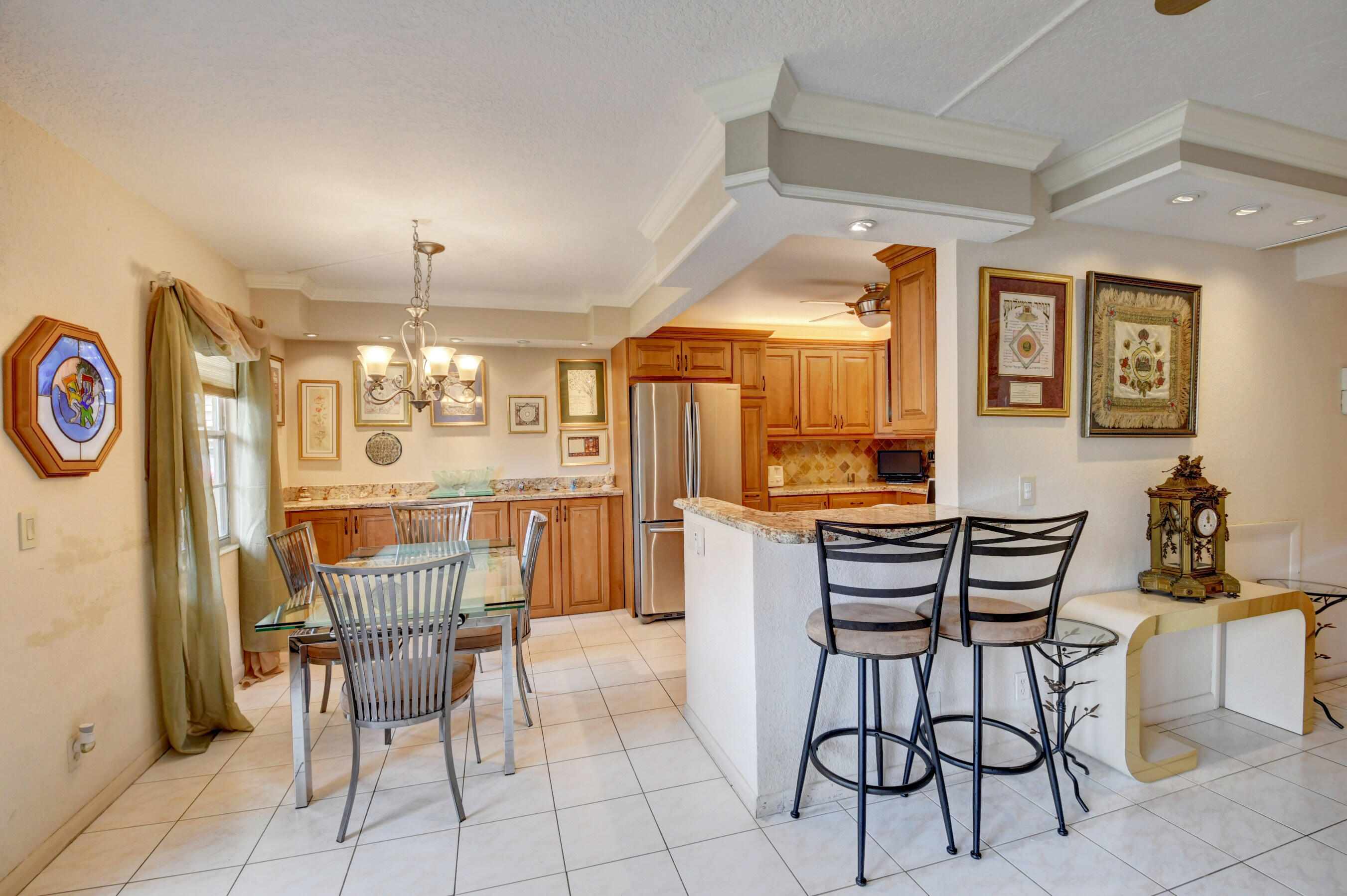 1045 Wolverton C, Unit 1045 Boca Raton, FL 33434 - Photo 5 of 67 a view of a dining room with furniture and chandelier