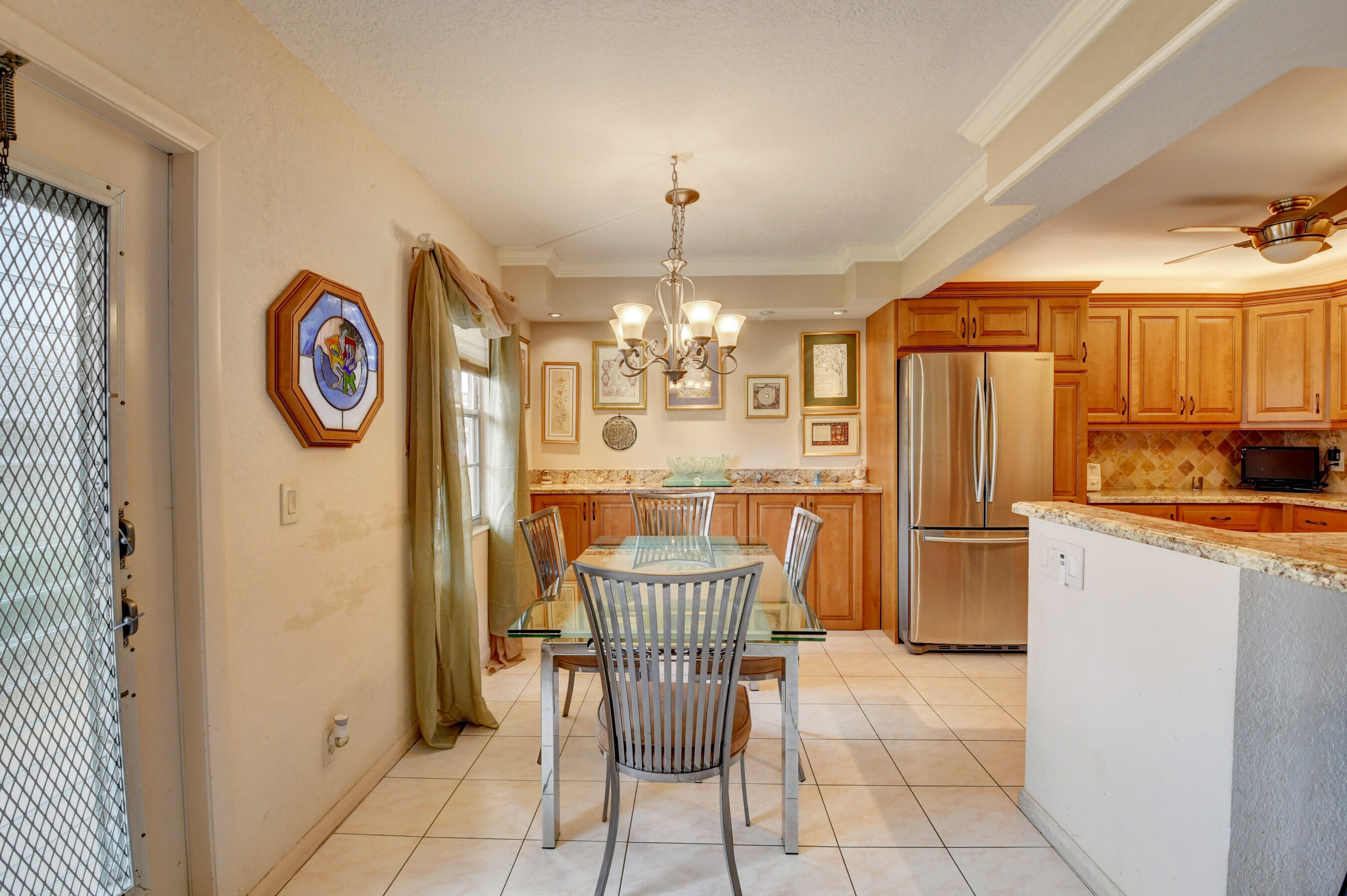 1045 Wolverton C, Unit 1045 Boca Raton, FL 33434 - Photo 6 of 67 a view of a dining room with furniture and chandelier