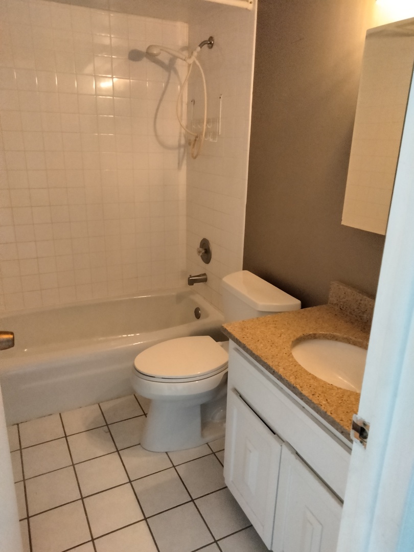 896 South Plum Grove Road, Unit 217 Palatine, IL 60067 - Photo 13 of 15 a bathroom with a granite countertop sink a toilet and shower