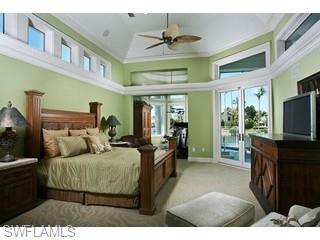 333 Devils Bight Naples, FL 34103 - Photo 5 of 8 a living room with furniture a flat screen tv and a refrigerator