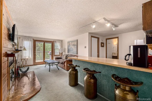 a living room with furniture a flat screen tv and gym equipment