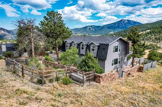 a view of a white house with a yard and sitting area