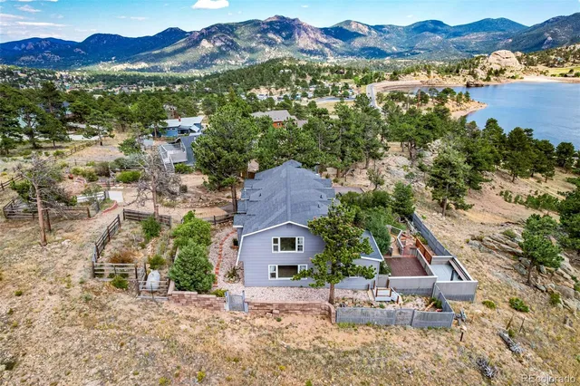an aerial view of houses with a lake and mountain view