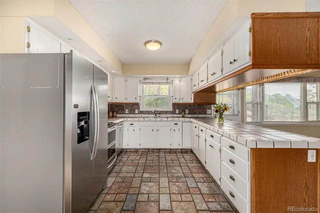 a kitchen with granite countertop stainless steel appliances a sink and cabinets