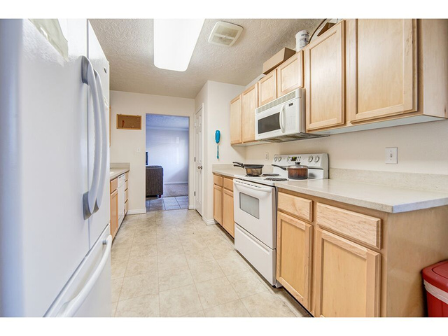 865 North 500 West, Unit 5 Provo, UT 84604 - Photo 3 of 14 Kitchen featuring light wood cabinetry, white appliances, and a built-in microwave