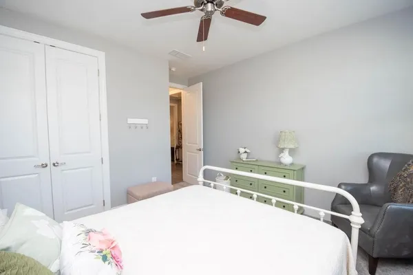 a bedroom with a bed a chandelier and a dresser