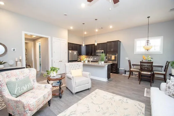 a living room kitchen with furniture and a wooden floor