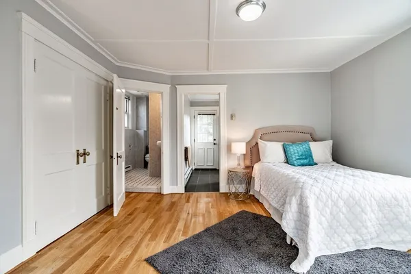 a bedroom with a bed and wooden floor