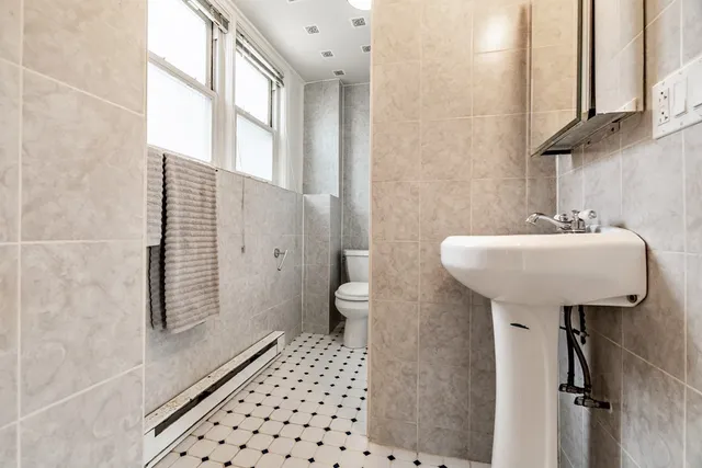 a bathroom with a sink toilet and a mirror