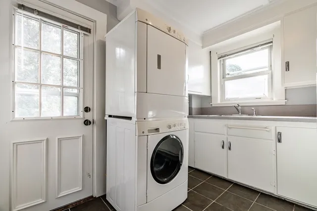 a bathroom with a sink a washer and dryer with wooden floor