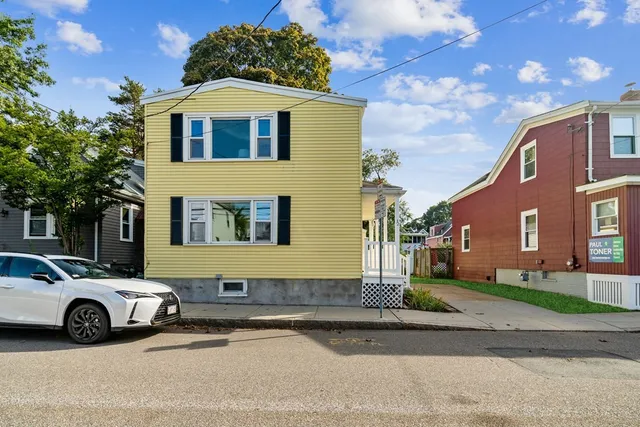 a blue and white car parked in front of a house