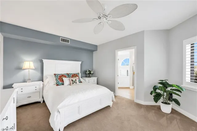 a bedroom with a bed a chandelier and a potted plant