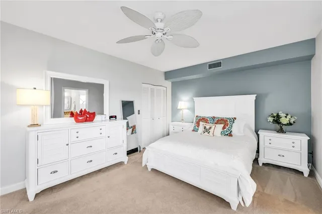 a bedroom with a bed a chandelier and a dresser