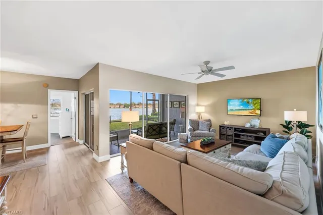 a living room with furniture wooden floor and a large window