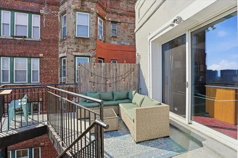 a view of a balcony with furniture and wooden floor
