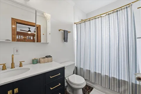 a bathroom with a sink a toilet and shower curtain