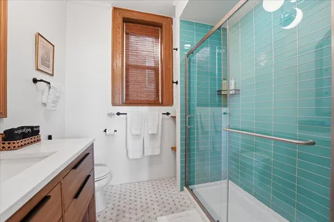 a bathroom with a sink a toilet and shower