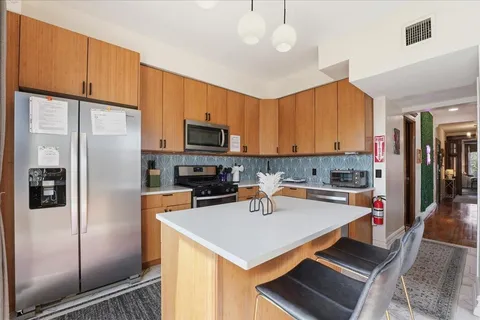a kitchen with a refrigerator a sink a stove and cabinets