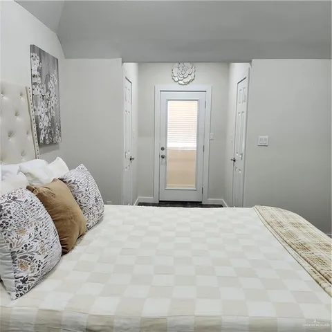 a bedroom with a large bed and a painting on the wall