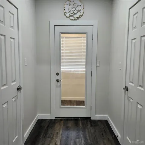 an empty room with wooden floor and a window