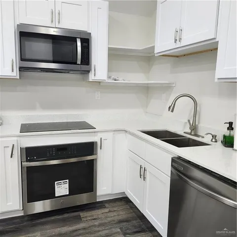 a kitchen with stainless steel appliances a stove microwave and sink