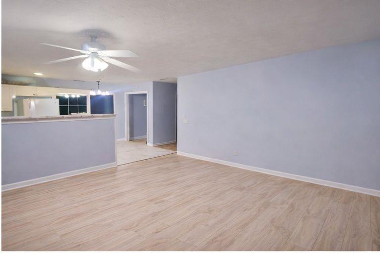 1637 Roman Point Drive Norcross, GA 30093 - Photo 2 of 9 a view of an empty room with chandelier fan and wooden floor