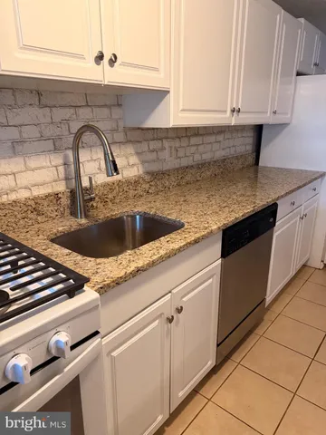 a kitchen with granite countertop a sink and cabinets