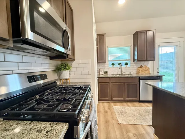 a kitchen with a stove a sink and a microwave