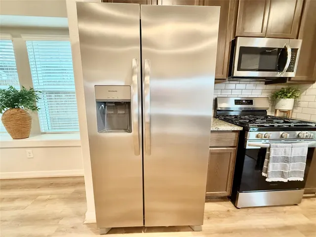 a kitchen with a refrigerator and a stove