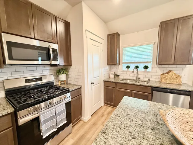 a bathroom with a granite countertop sink a toilet a mirror and bathtub