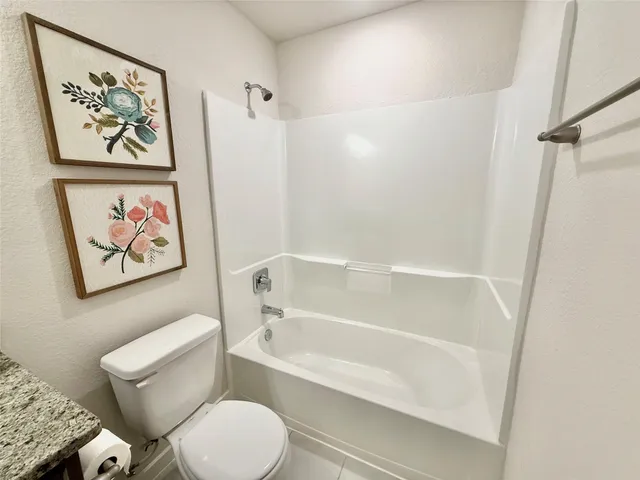 a white toilet sitting next to a bath tub