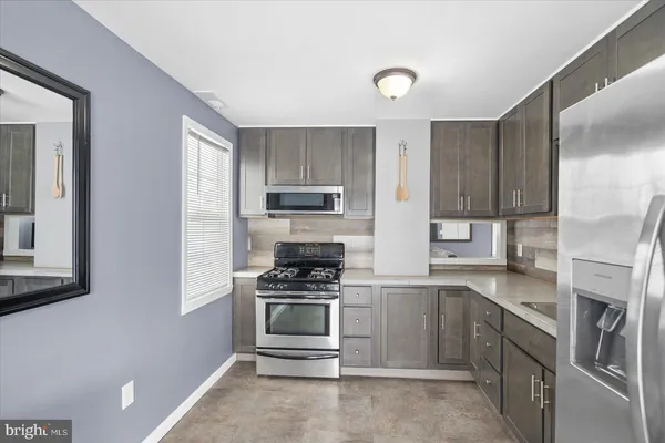 a kitchen with stainless steel appliances a stove sink and cabinets