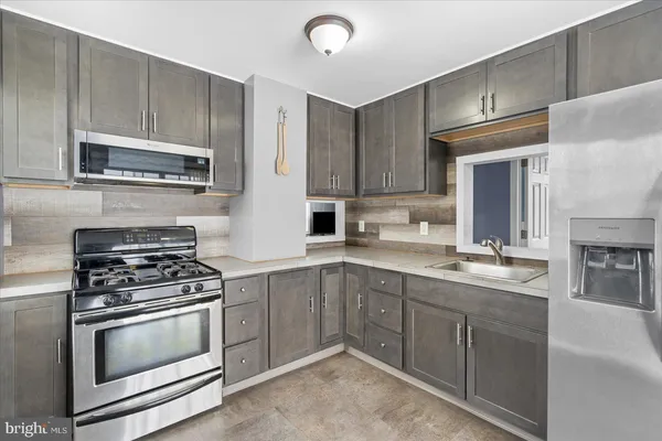 a kitchen with granite countertop a stove sink and cabinets