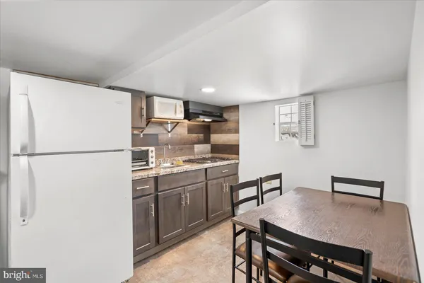 a kitchen with stainless steel appliances granite countertop a refrigerator a sink a stove and a refrigerator