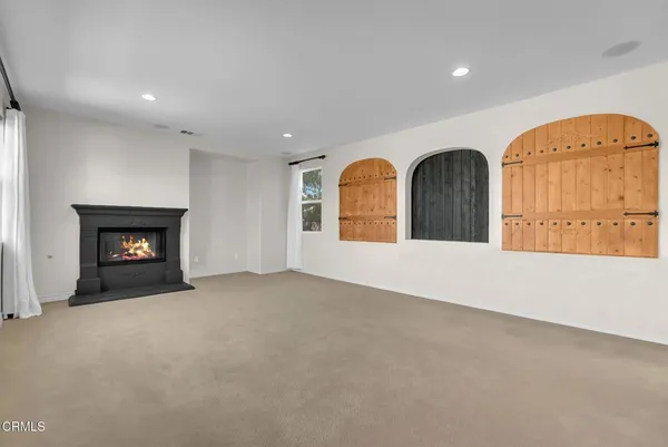 a view of an empty room with a window and fireplace