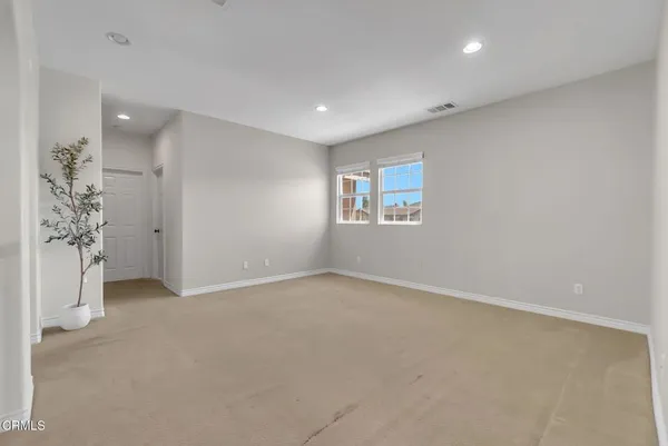 a bedroom with a bed chandelier and a window