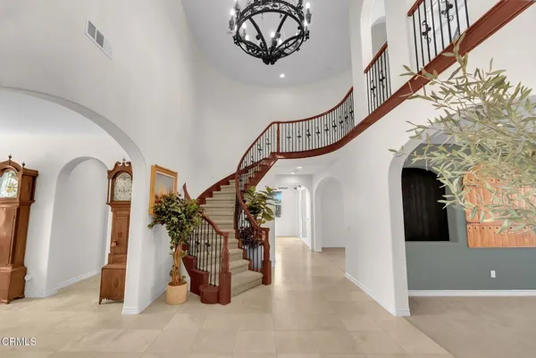 a view of staircase with lots of frames on wall and a potted plant
