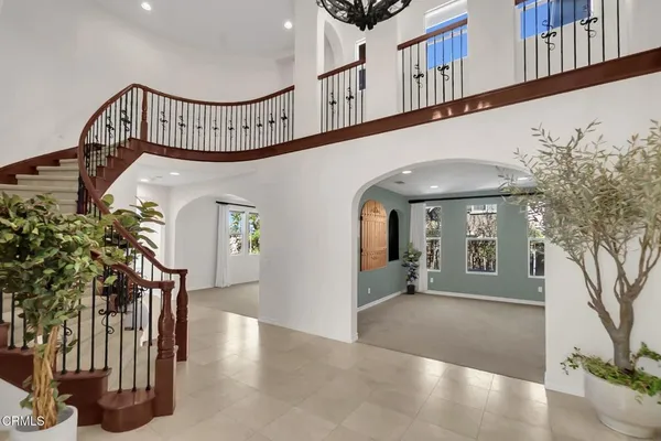 a view of staircase with railing and a chandelier