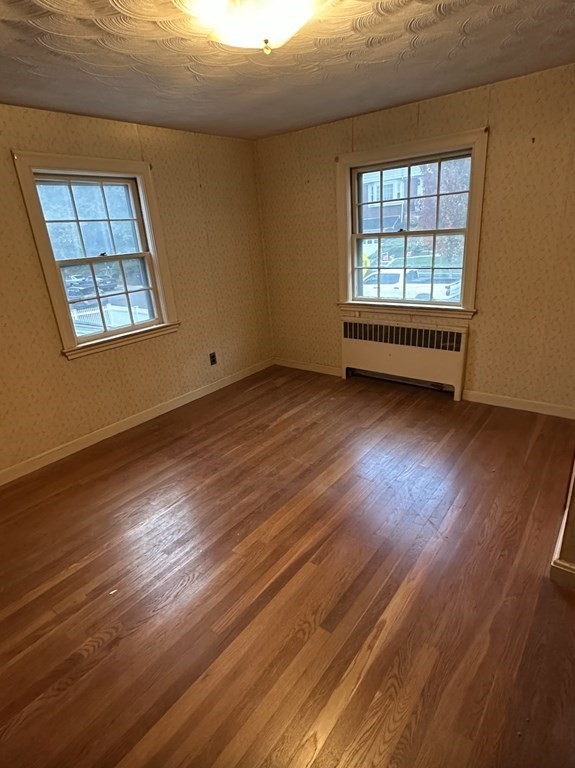 72 Redlands Road Boston, MA 02132 - Photo 16 of 19 an empty room with wooden floor and windows