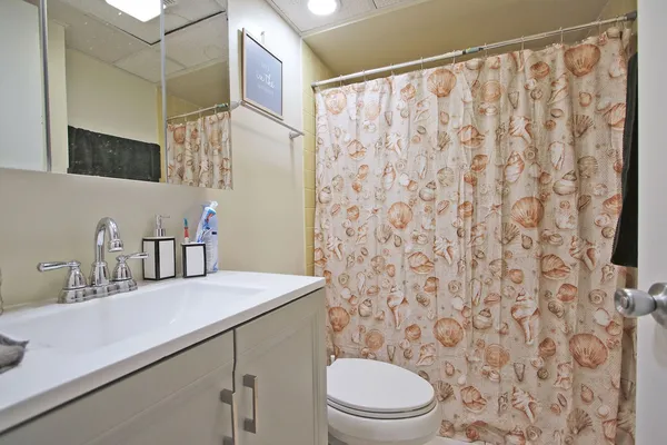 a bathroom with a sink a toilet and shower curtain
