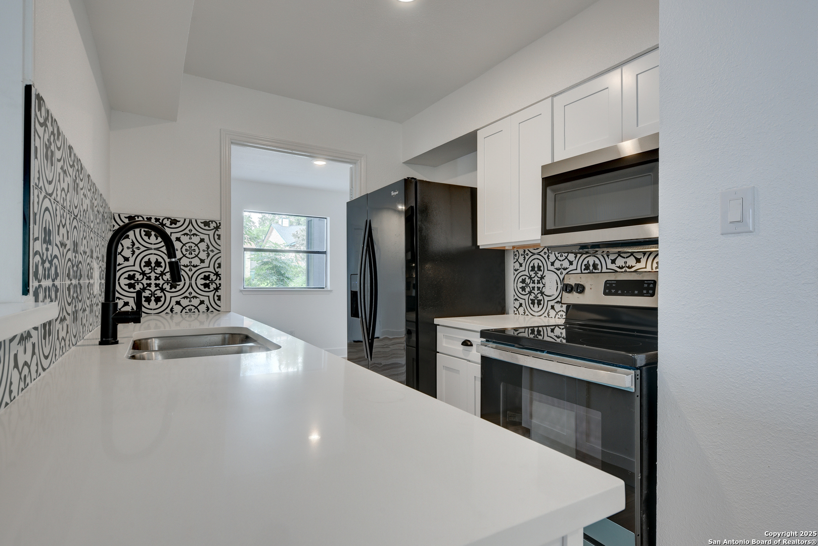 8903 Ridge Sky Street San Antonio, TX 78250 - Photo 3 of 7 a kitchen with granite countertop a refrigerator stove and microwave
