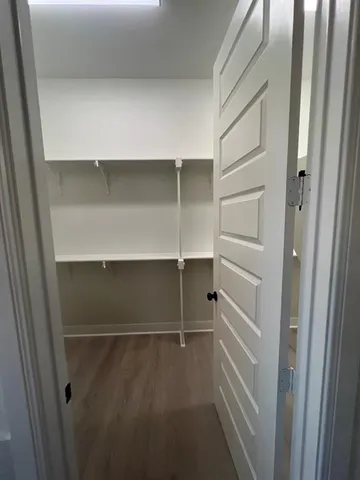 a view of walk in closet with empty racks