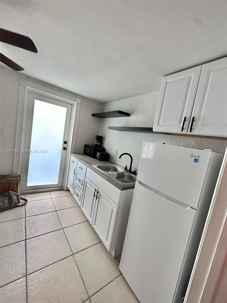 1375 Northwest 84th Terrace, Unit A Miami, FL 33147 - Photo 4 of 11 a kitchen with a sink a stove and cabinets