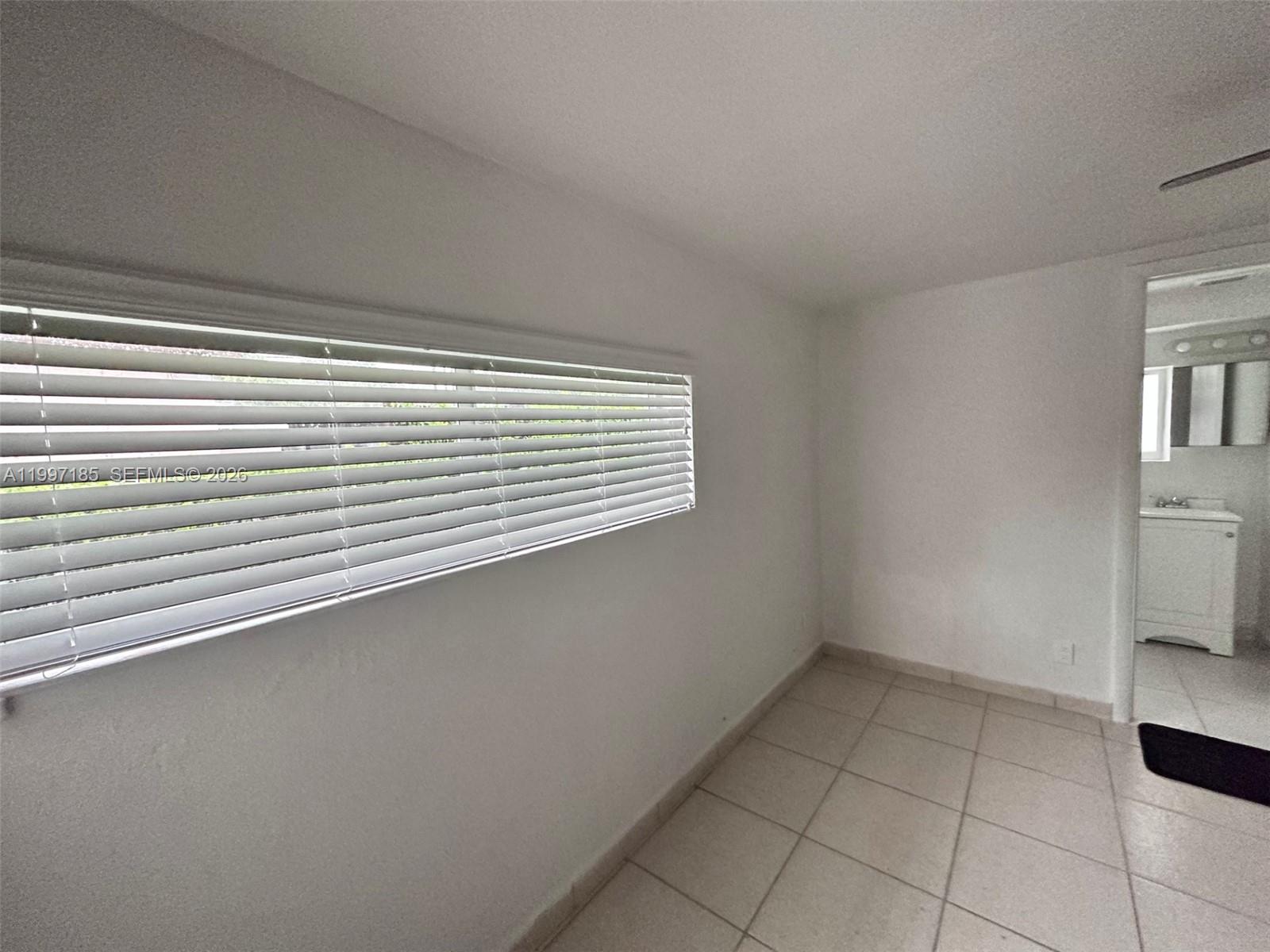 1375 Northwest 84th Terrace, Unit A Miami, FL 33147 - Photo 6 of 11 a view of a room that has a window in it