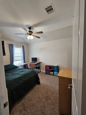 a bedroom with a bed and a ceiling fan