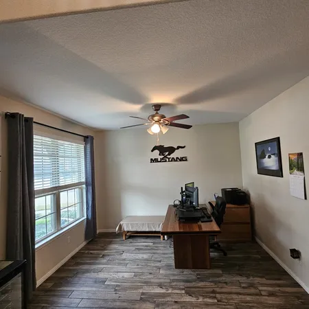 a view of a workspace with furniture and a window