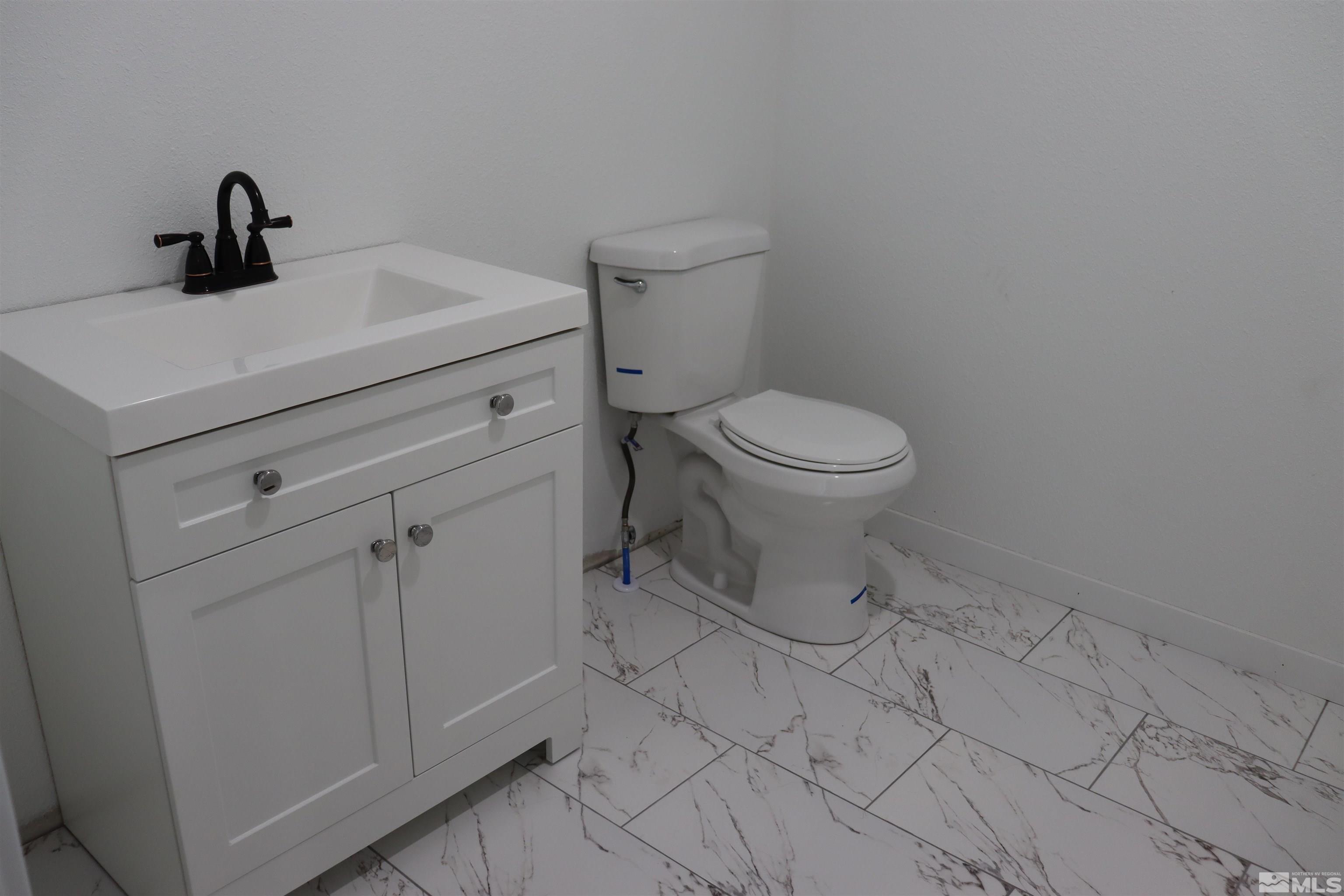 2650 Apollo Way Reno, NV 89503 - Photo 13 of 36 a bathroom with a toilet sink and vanity